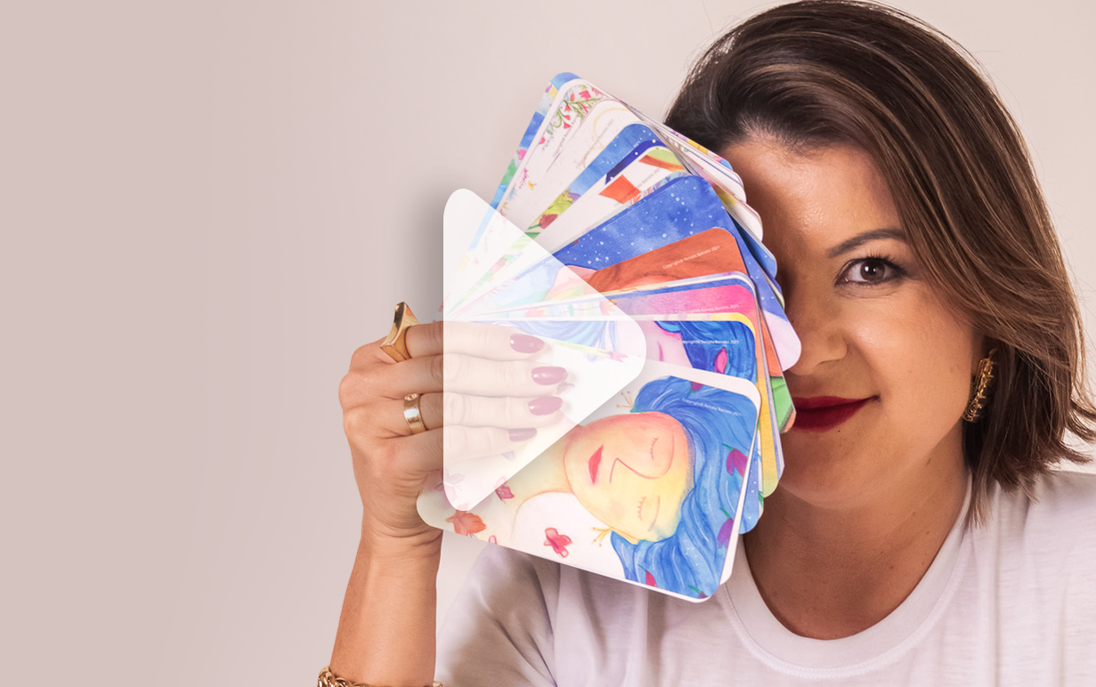Michélle Milanni segurando cartas coloridas em frente ao rosto